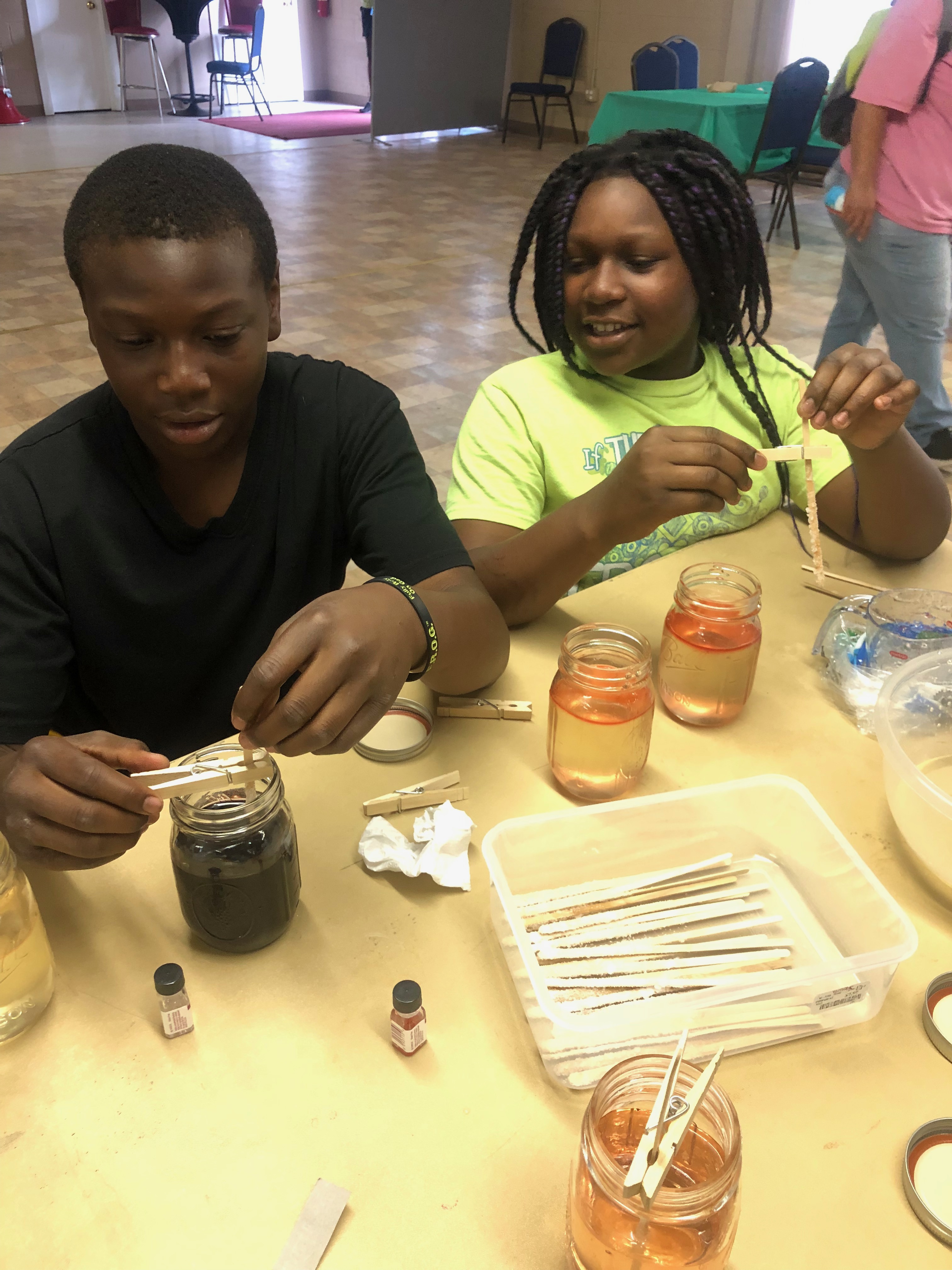 Children Submerging their sticks into the syrup hypersolution