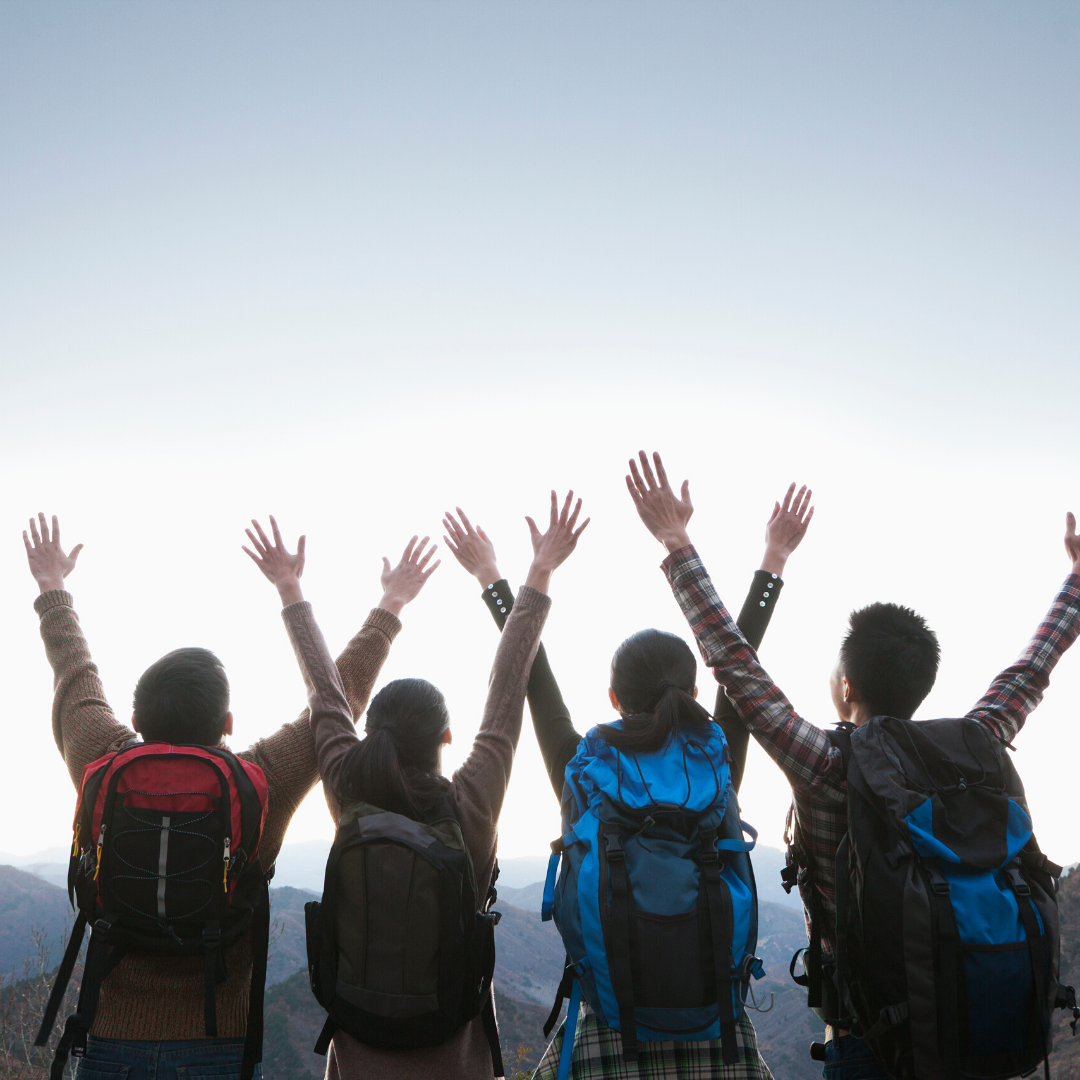 Kids celebrating at the top of a mountain of a hike.