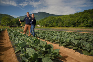 2 people standing in field with collards