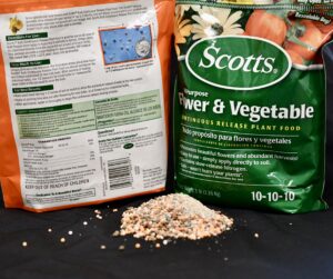image of Scott's flower and vegetable fertilizer with a pile of the raw fertilizer in front of it