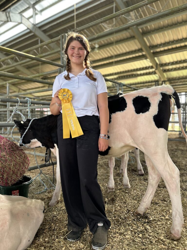 Emma Kate Van Domelen with her dairy calf, displaying her fourth place ribbon